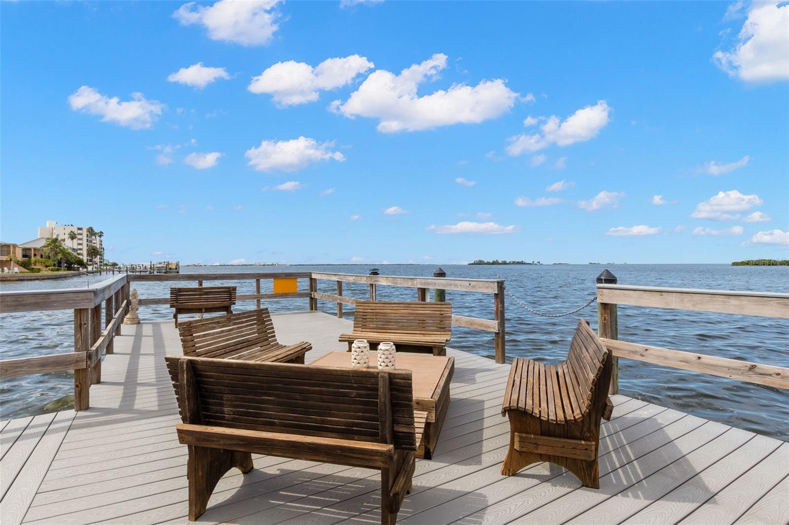 Spacious community dock featuring comfortable seating and panoramic water views — an ideal setting for enjoying the coastal breeze.
