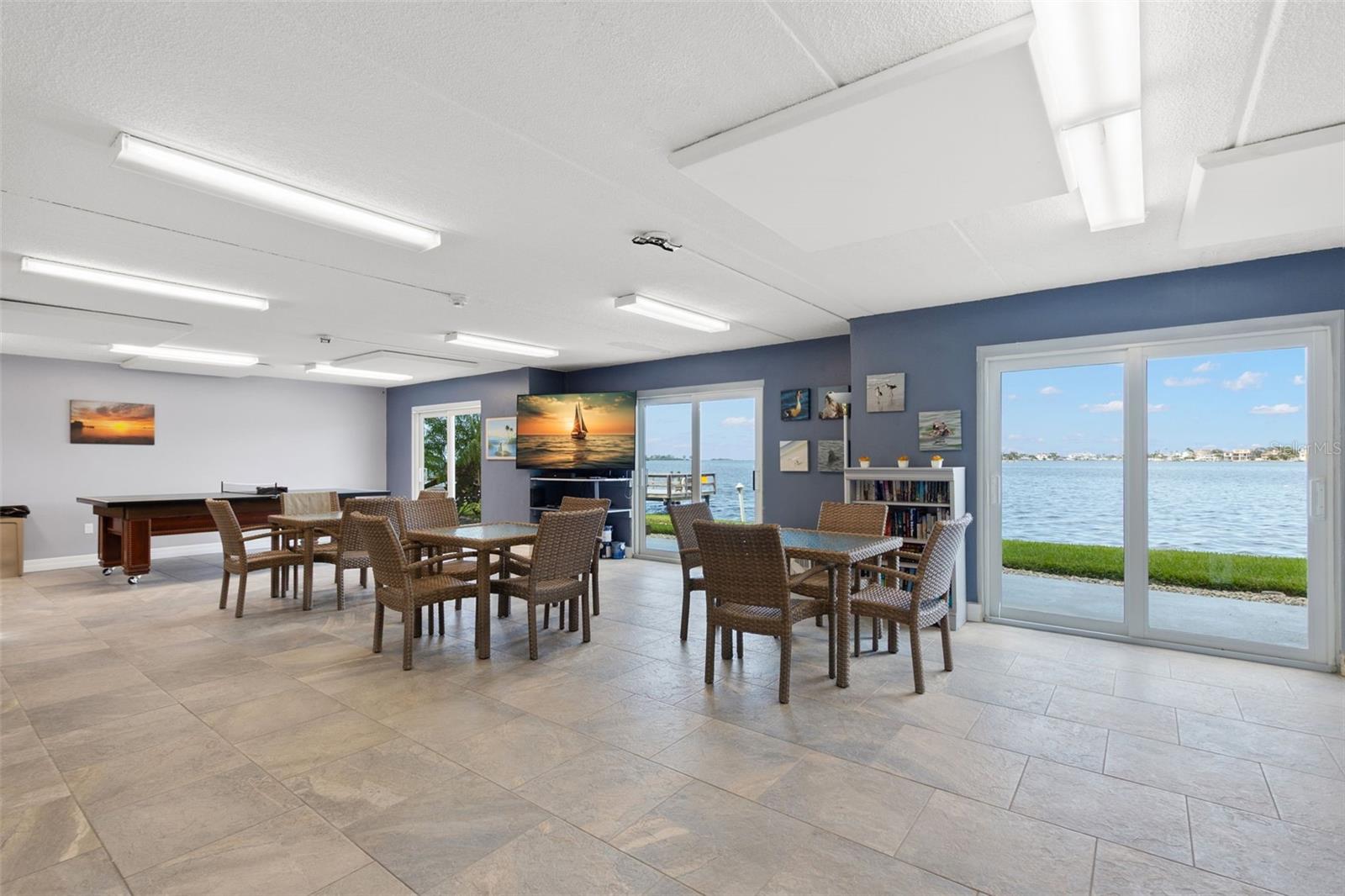Beautifully maintained waterfront community clubhouse offering seating areas, recreation space, and direct access to panoramic bay views.