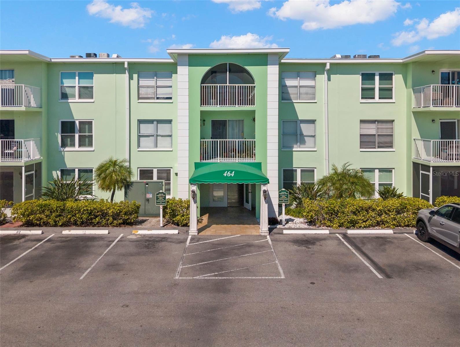 Welcoming, well-maintained building entrance featuring covered entry and convenient assigned parking directly in front.