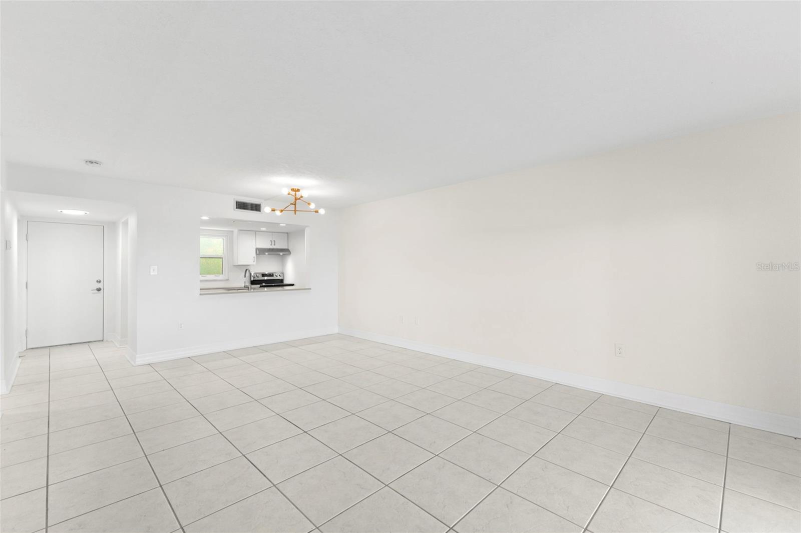 Spacious dining/living area with tile flooring and direct kitchen access, designed for comfortable daily living and effortless hosting.