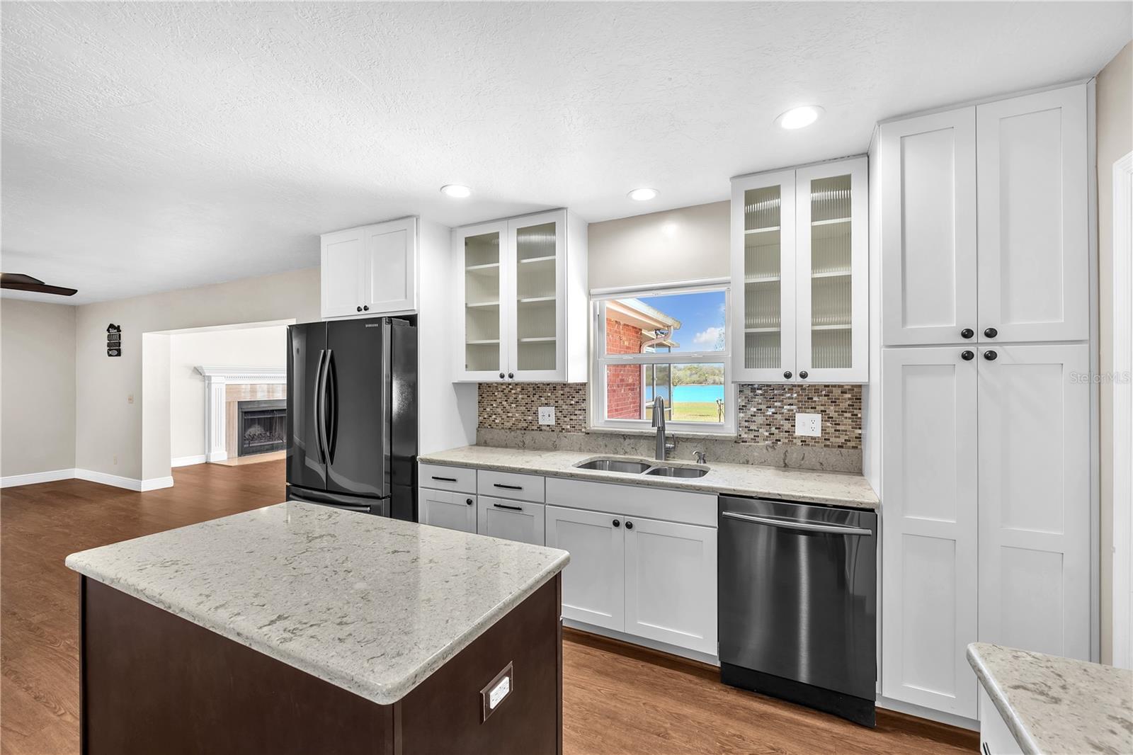 42” white cabinetry features decorative fluted glass accents, soft-close doors, bronze hardware, and a separate pantry.
