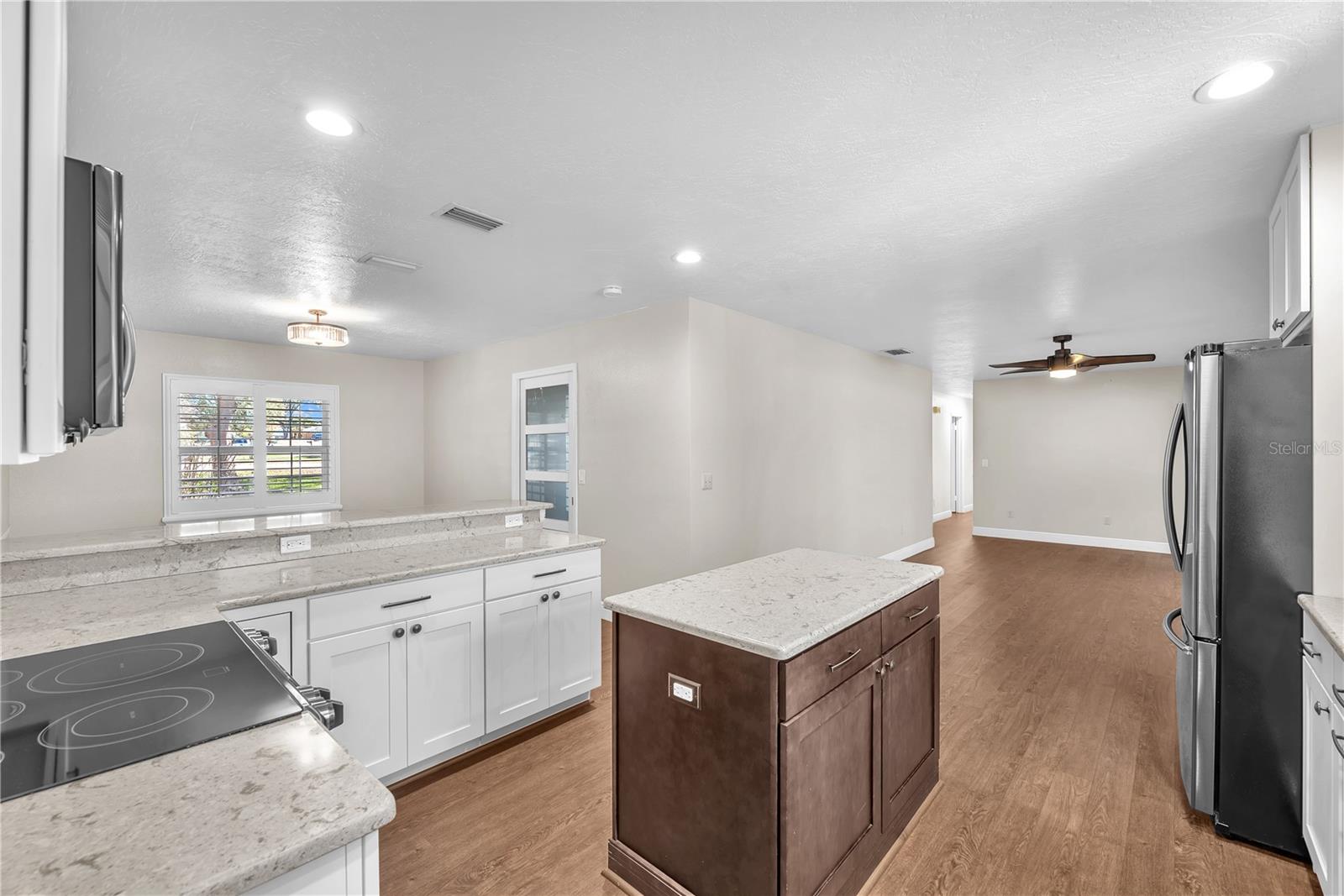 An island with a rich cherry-stained base provides ample prep space