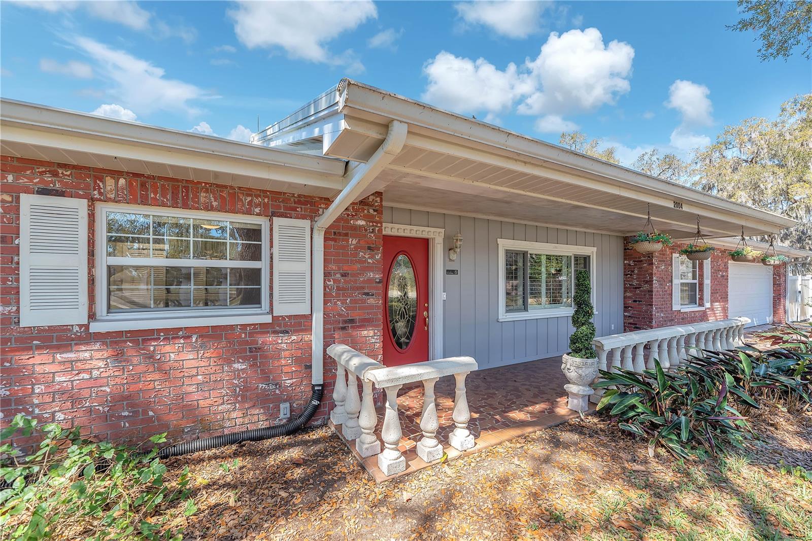 A majestic oak tree shades a welcoming front porch.