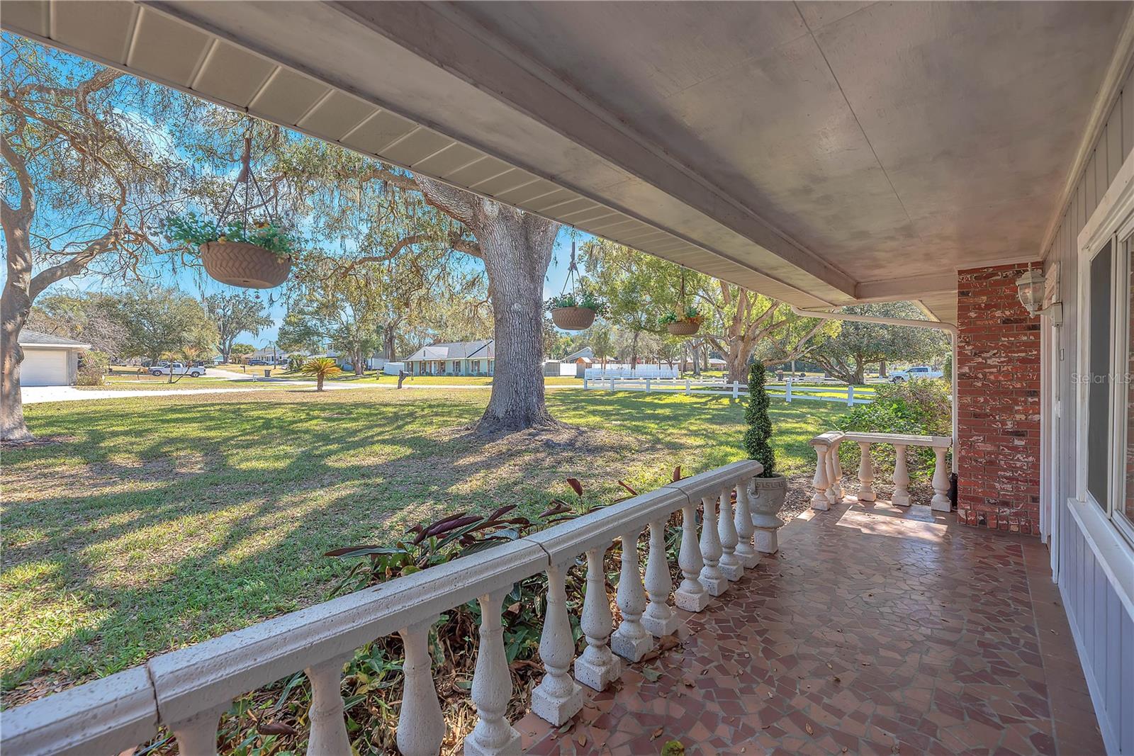 The front porch over looks a private front yard on a peaceful cul-de-sac in the desirable Valrico Lake Estates and is finished with terracotta mosaic tile.