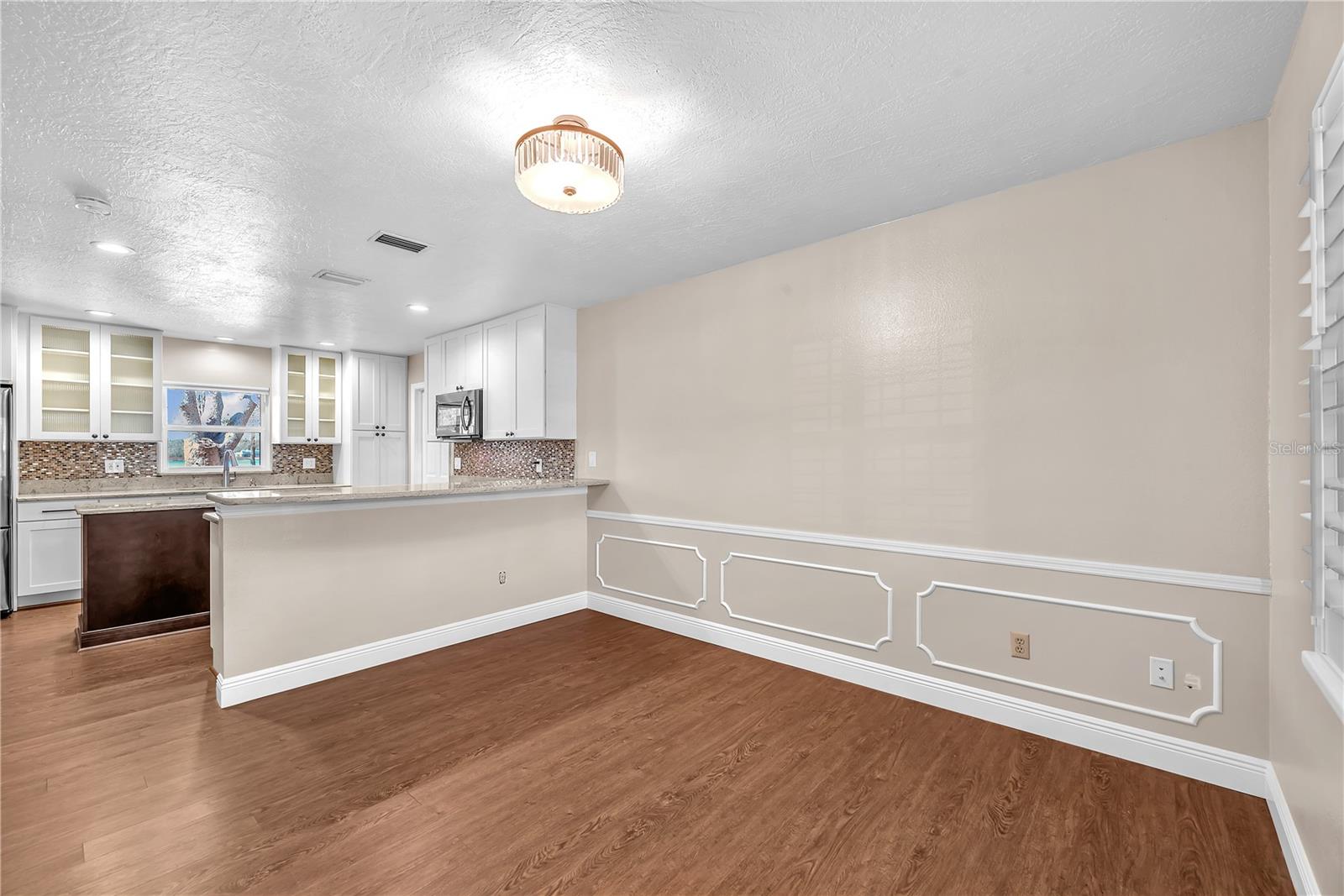 The casual dining area is 11'x12' and has decorative chair-rail moulding with judges-panels below and plantation shutters on the window.