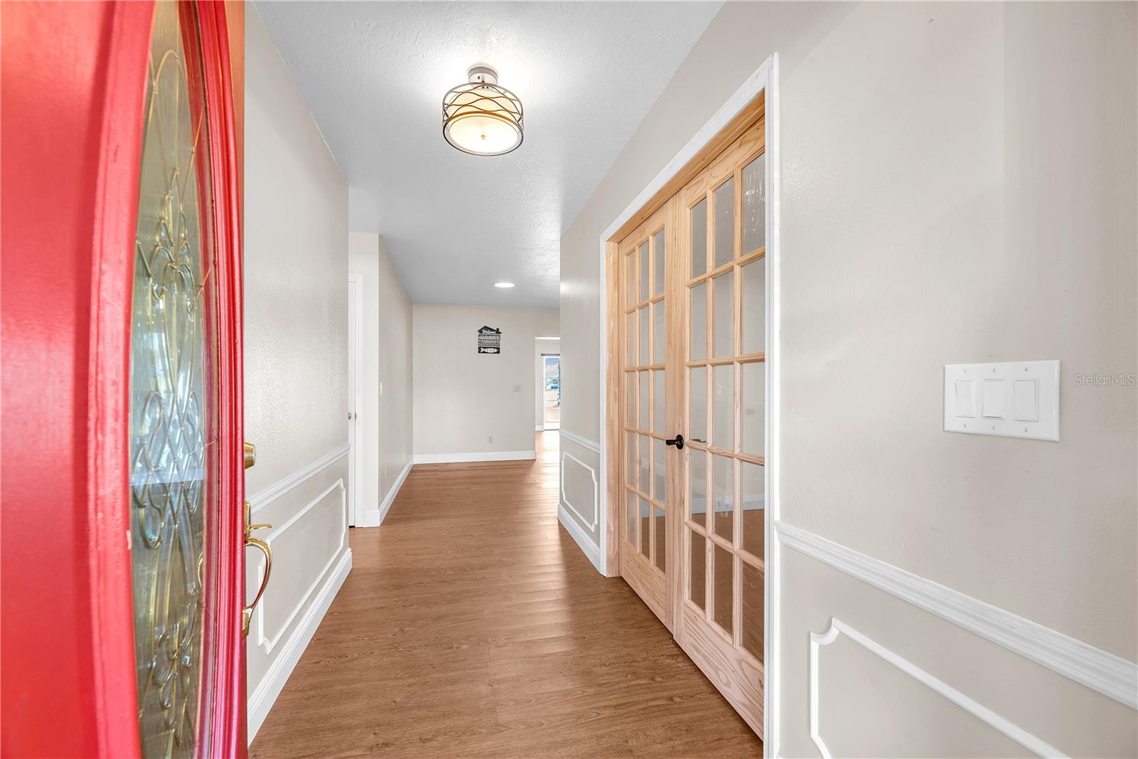 A leaded-glass insert fills the foyer with natural light, highlighting custom millwork.