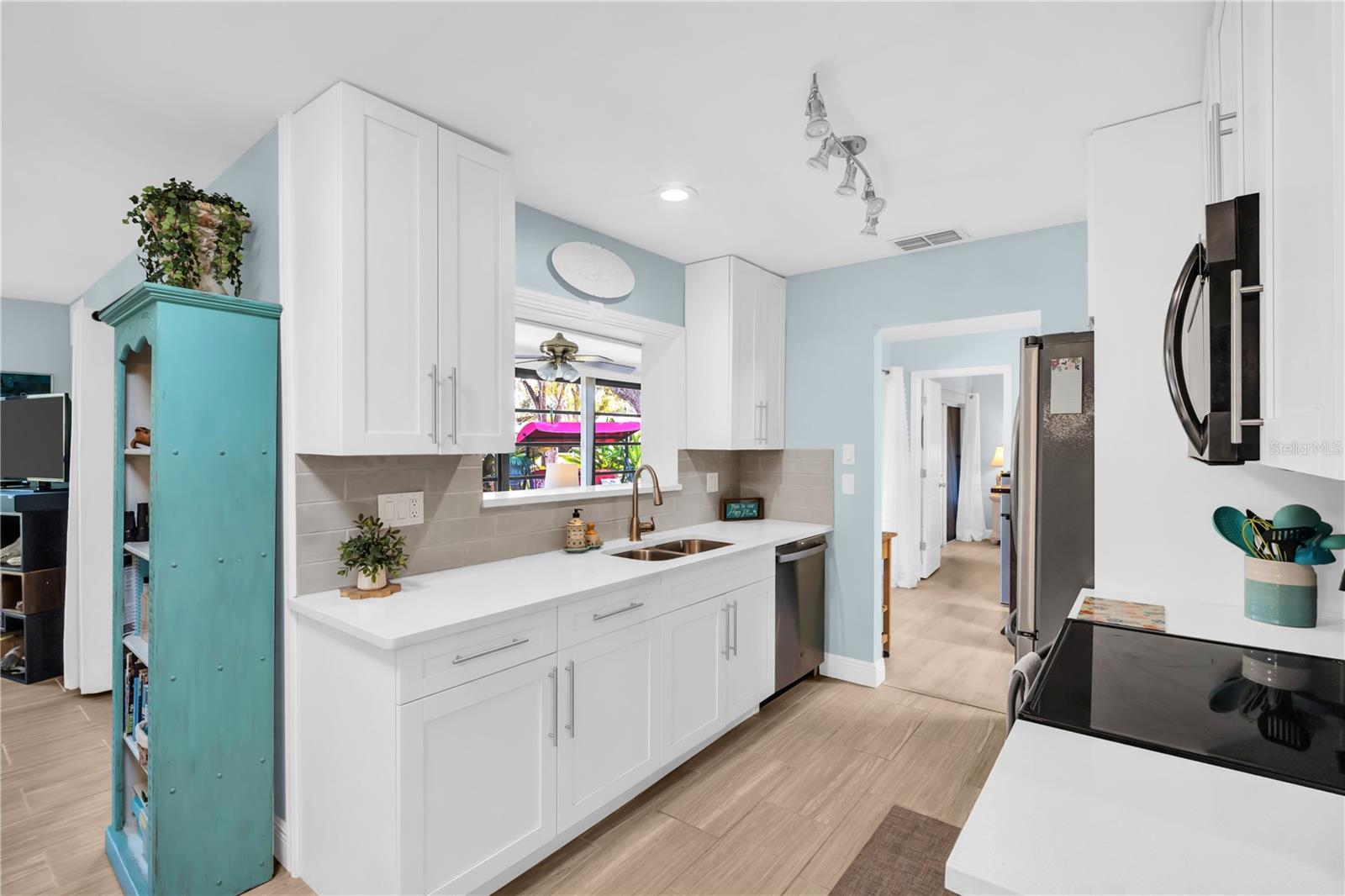 Open pass thru window to the sunroom keeps you in the center of all the interaction with friends and family ~