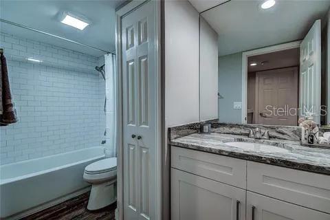 Second bathroom with tub and granite top