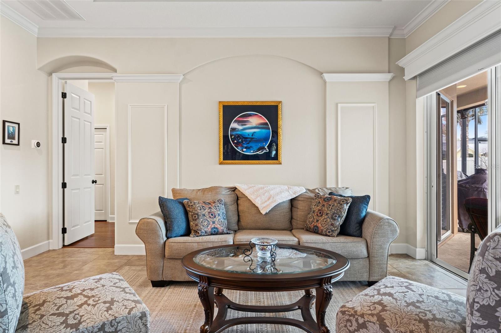 Expansive sliding glass doors lead to the covered lanai, extending the living space outdoors and allowing for effortless indoor-outdoor entertaining.