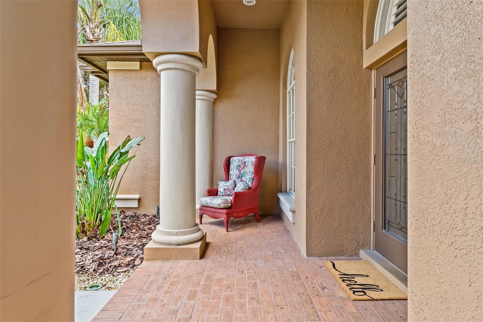 Enjoy a private covered porch with tile flooring and architectural columns, perfect for a quiet morning coffee or welcoming guests in style.