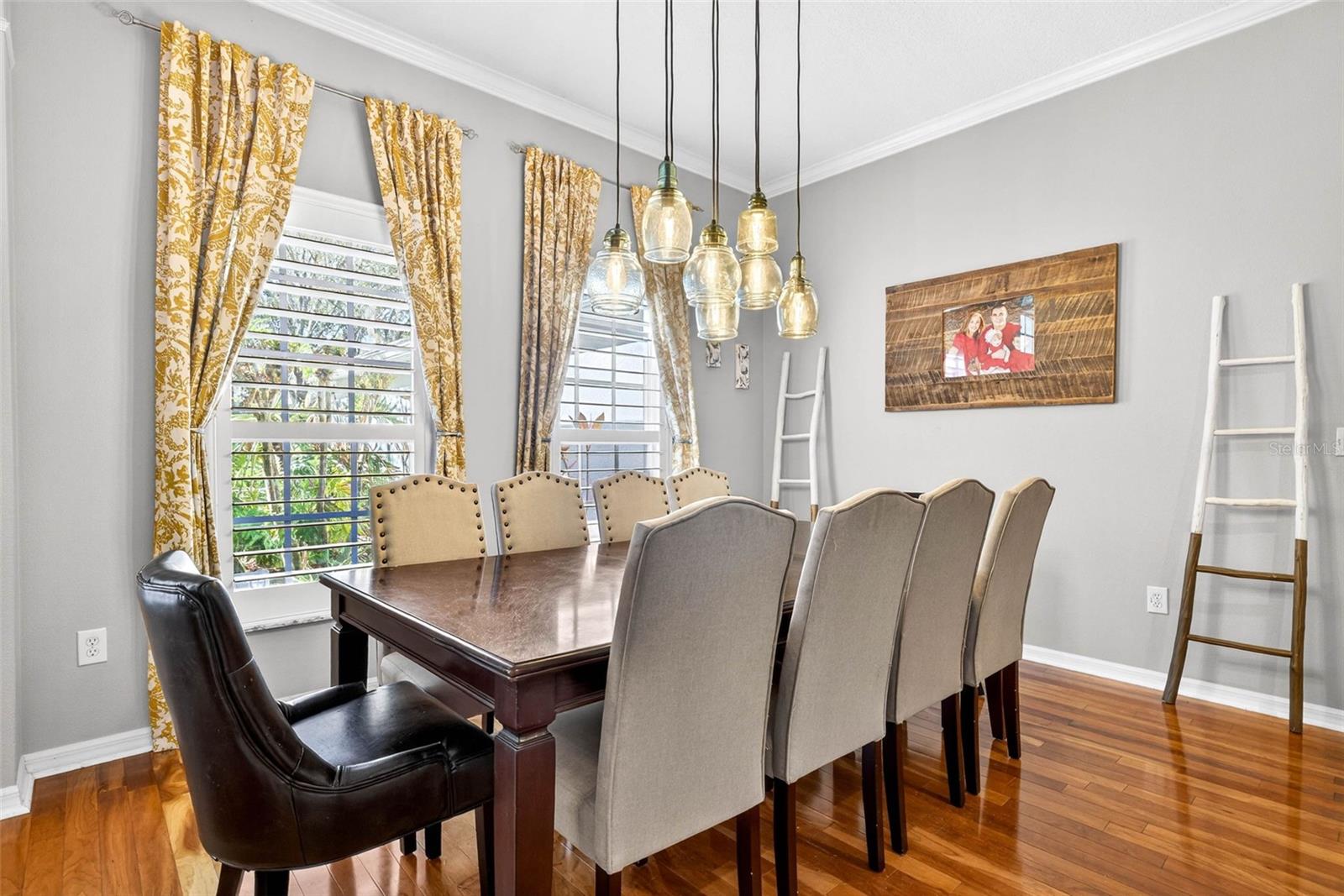 Plantation shutters and a grand light fixture and crown molding anchor this formal dining area.