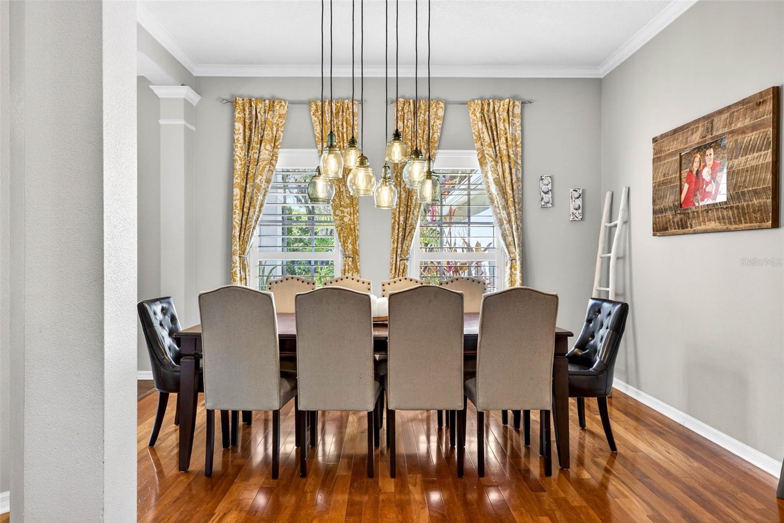 Formal dining with hardwood floors, crown molding and pantation shutters.