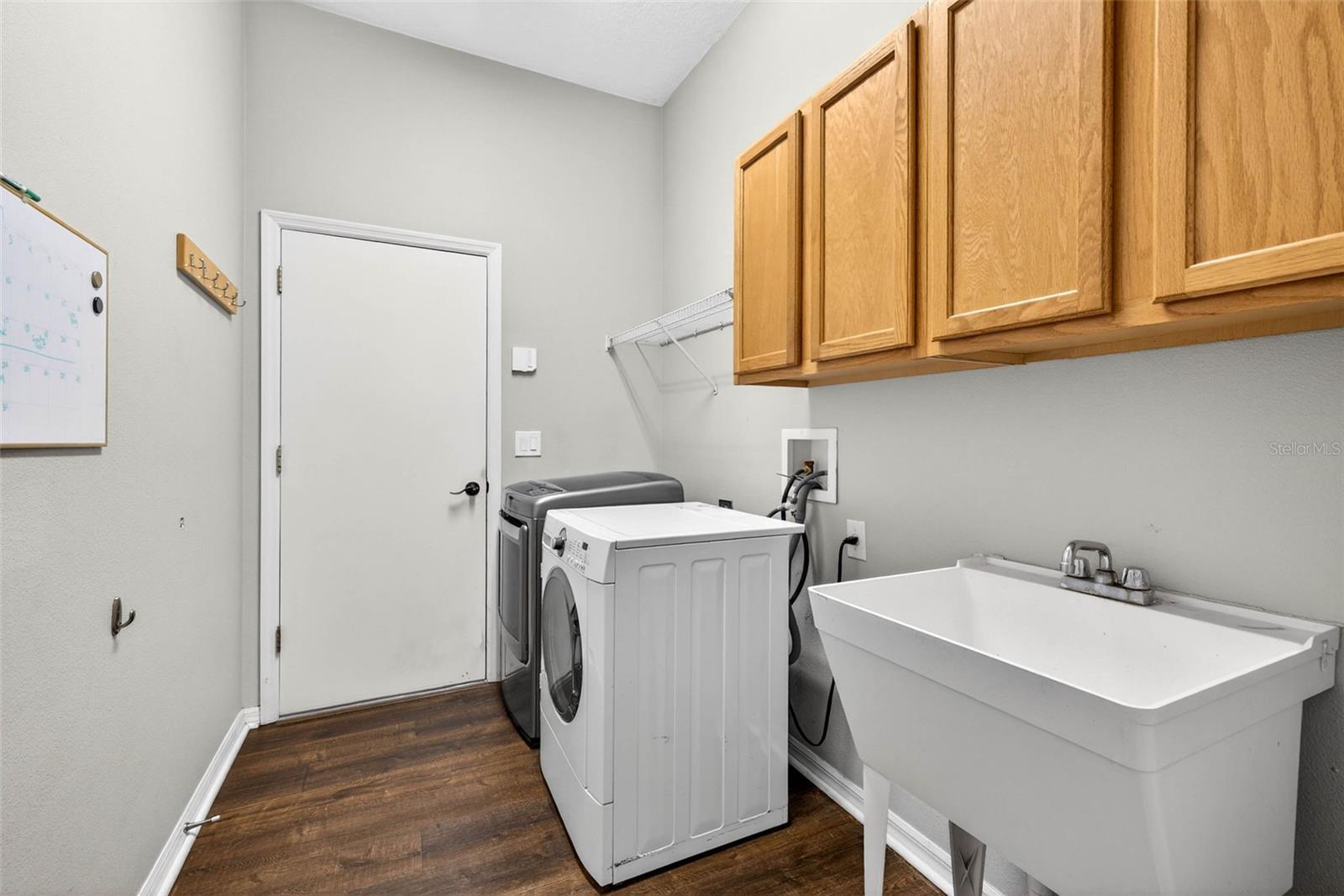 Laundry room with cabinets and sink. Washer/dryer do convey. Possibilities for buildout are endless in this space.