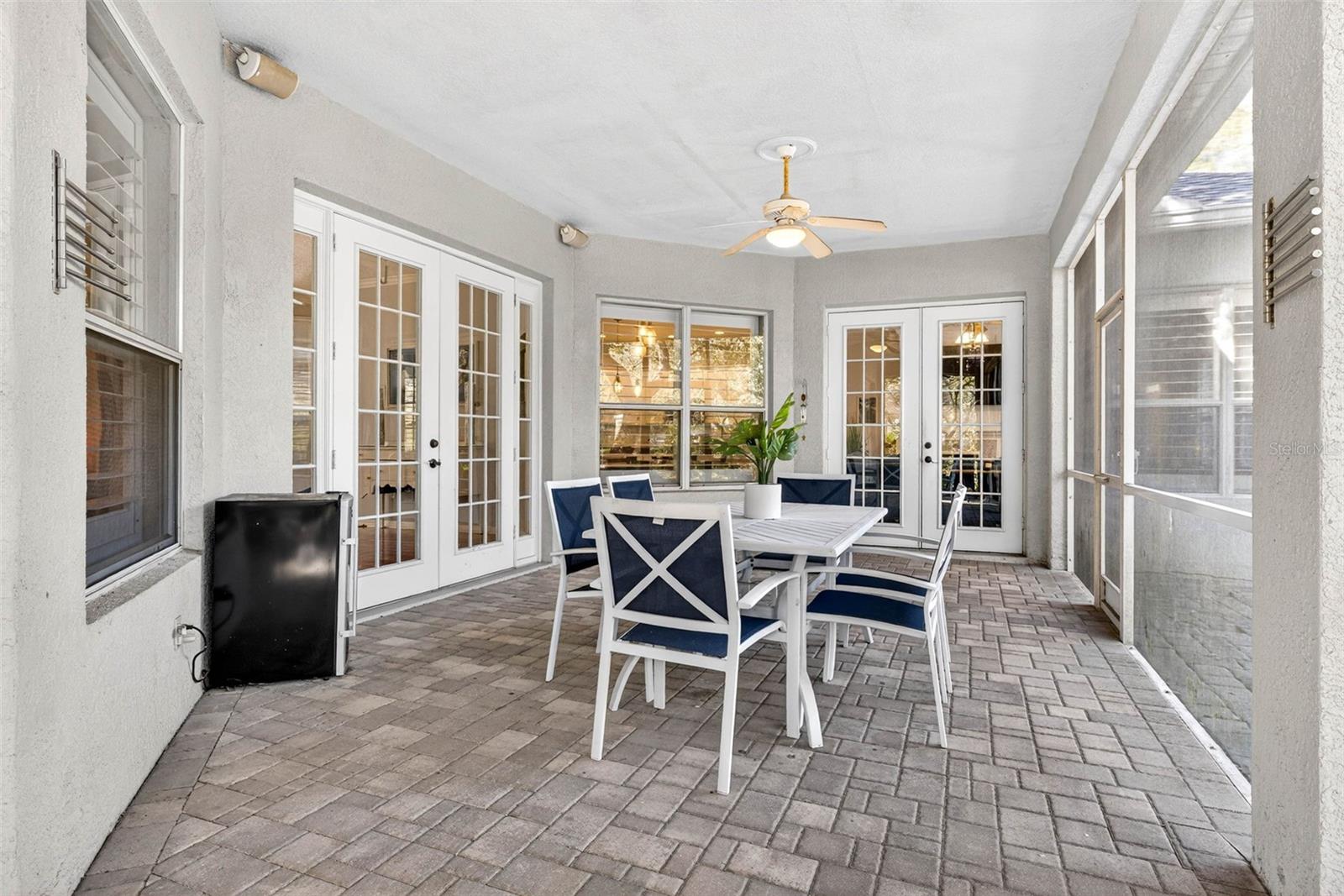 Screened lanai with extended roof for additional shade/climate control. French doors from formal area and living area