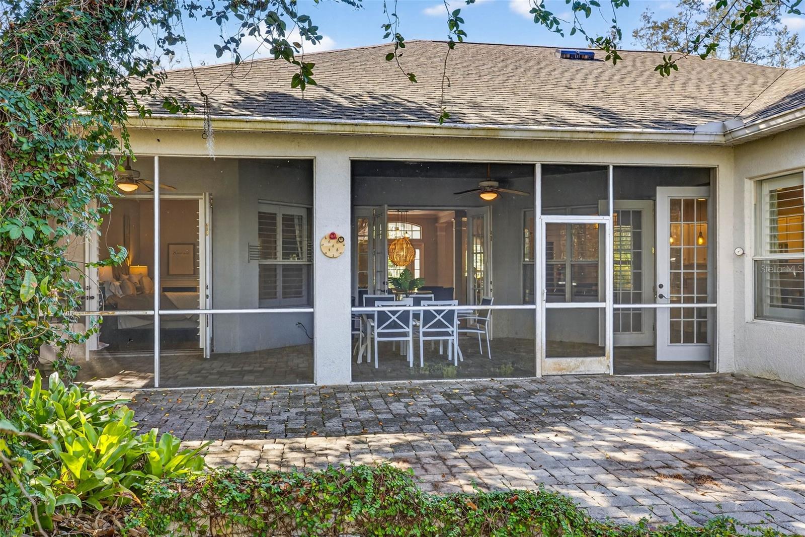 Exterior photo of screened lanai with french doors all opened.