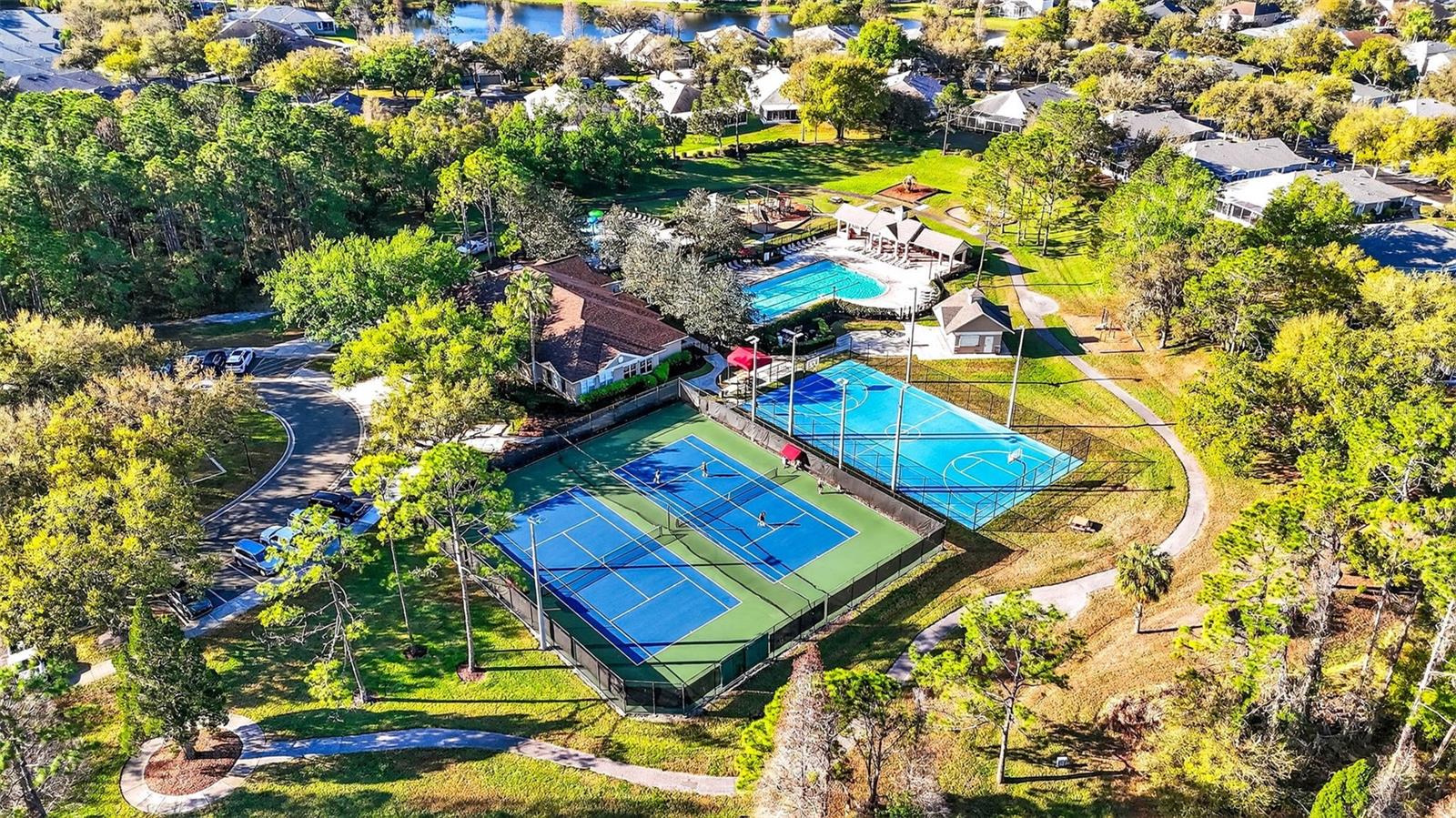 Overhead shot of the Osprey Club featuring tennis courts and basketball court as well as a junior olympic swimming pool and splash pad.