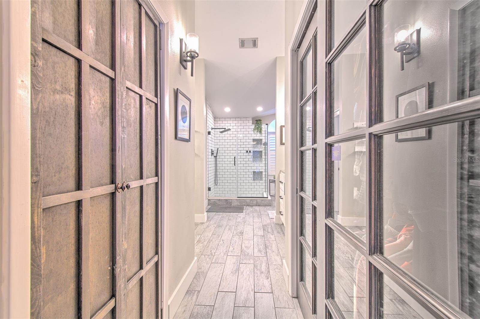 Custom Closets on either side of hall leading to Primary Bathroom
