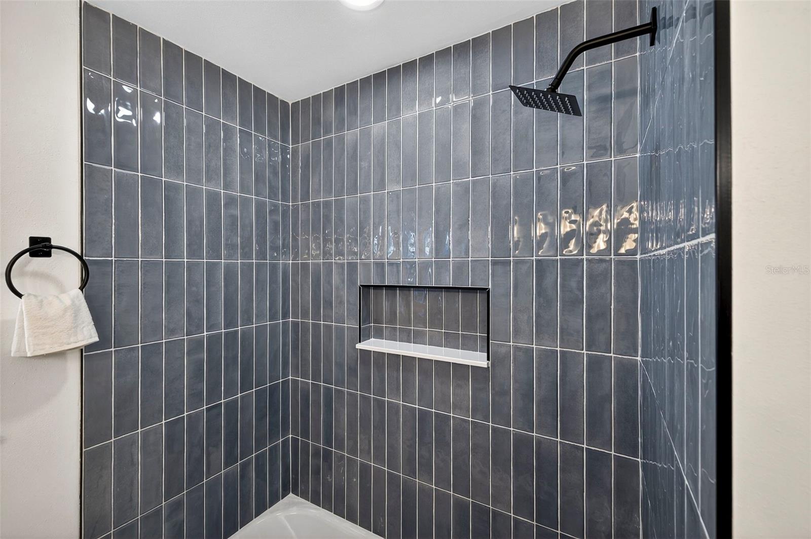 Custom porcelain tile surrounds the tub/shower for a modern look.