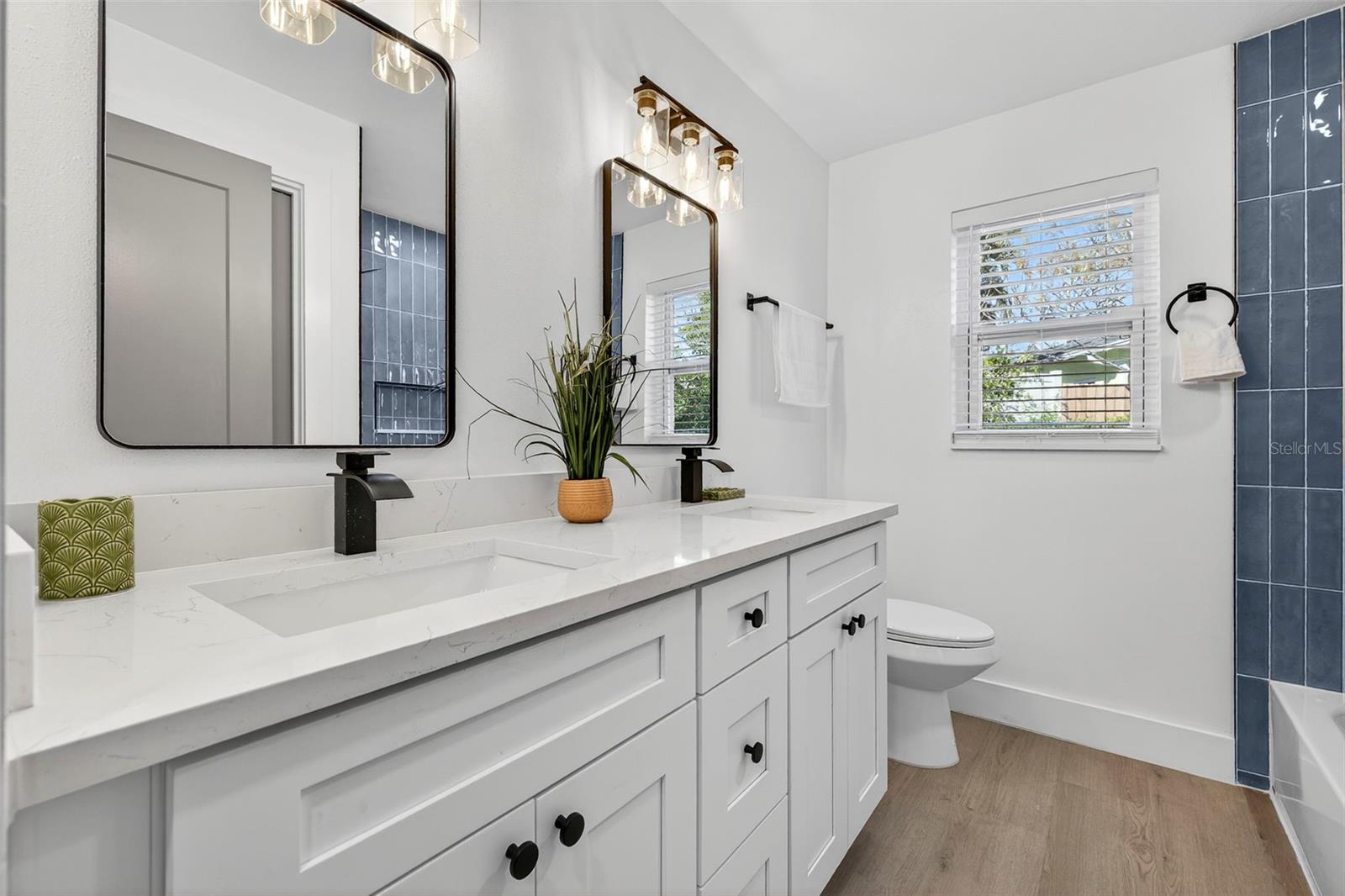 Updated bathroom with NEW DOUBLE VANITY and sleek black fixtures.
