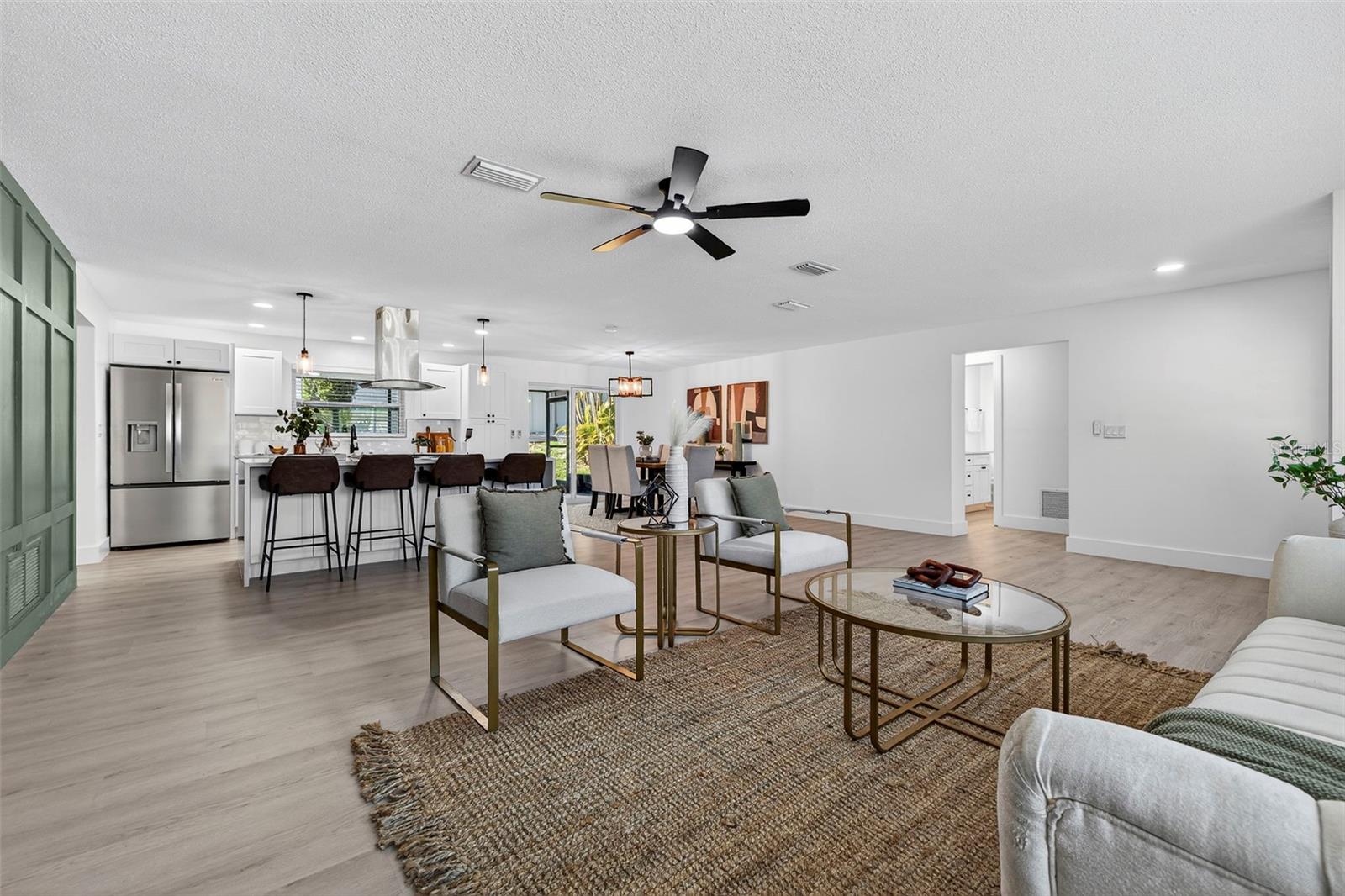 Seamless flow from living to kitchen highlights modern Florida lifestyle.