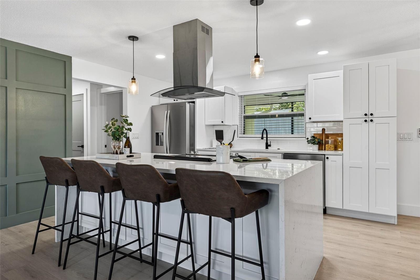 Quartz counters and designer island create a stunning centerpiece.