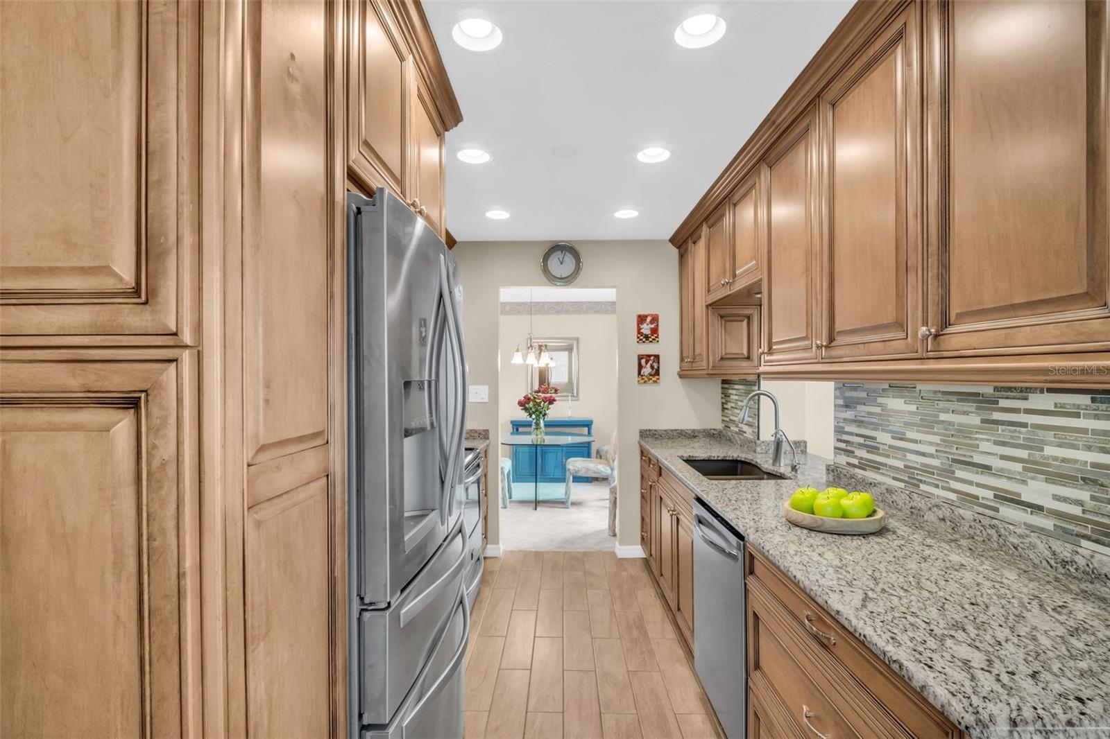 Solid wood custom cabinetry with under cabinet lighting, granite countertops, and recessed lighting~