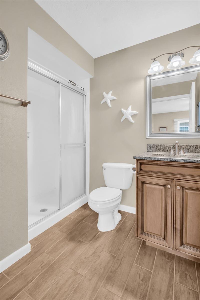 Updated guest bath with walk-in shower, newer vanity, granite countertop, & tasteful lighting~