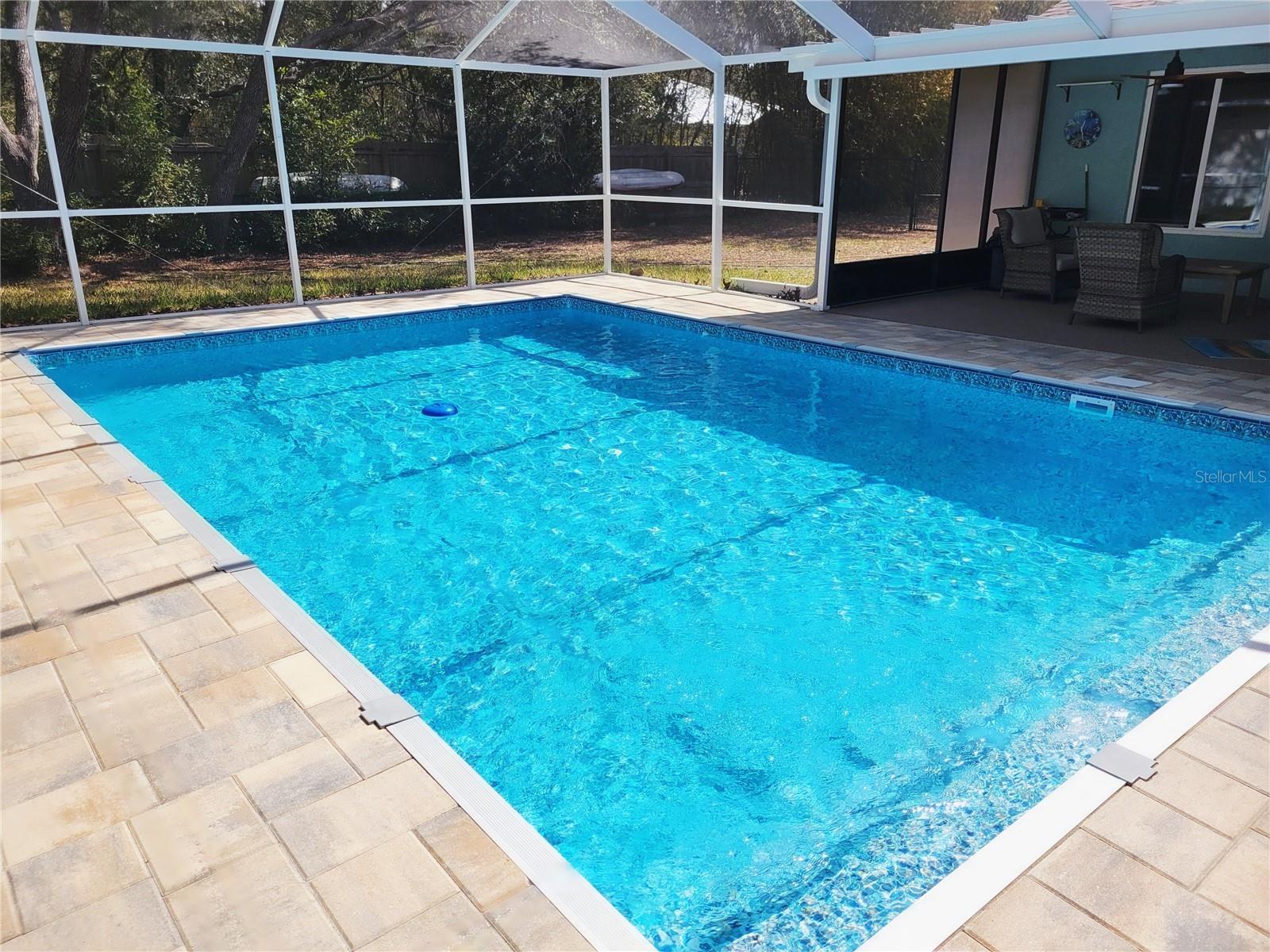Screened in pool area with pavers