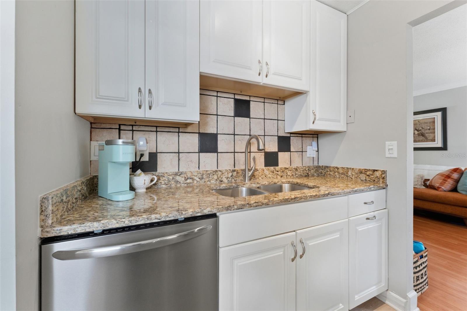 Convenient dishwasher paired with updated cabinetry offers both modern style and everyday functionality in this beautifully refreshed kitchen.
