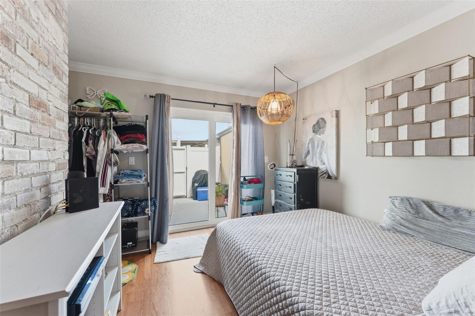 Creative bedroom setup within the living area, featuring sliding glass doors to the back patio — a versatile space that can easily adapt to your needs.