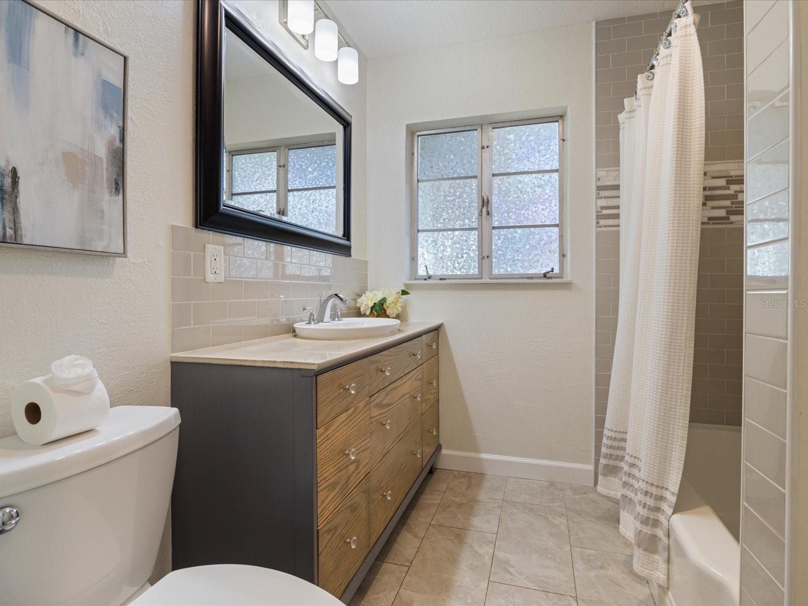 Updated guest bathroom with custom built vanity and shower/tub combo