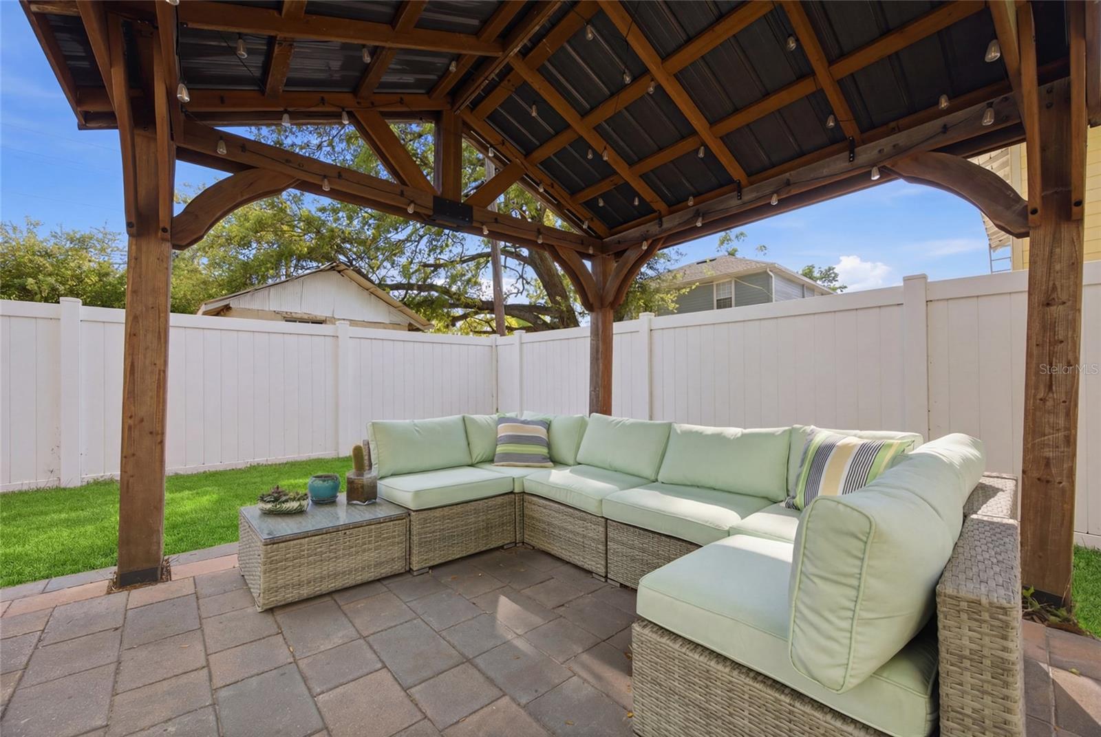 Pergola and pavers. Outdoor furniture conveys.