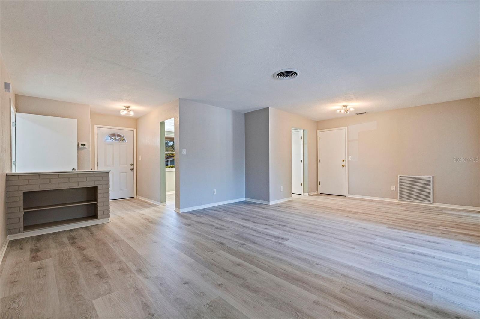 Foyer entry opens into a spacious combined living and dining area with updated vinyl plank flooring and neutral interior finishes.