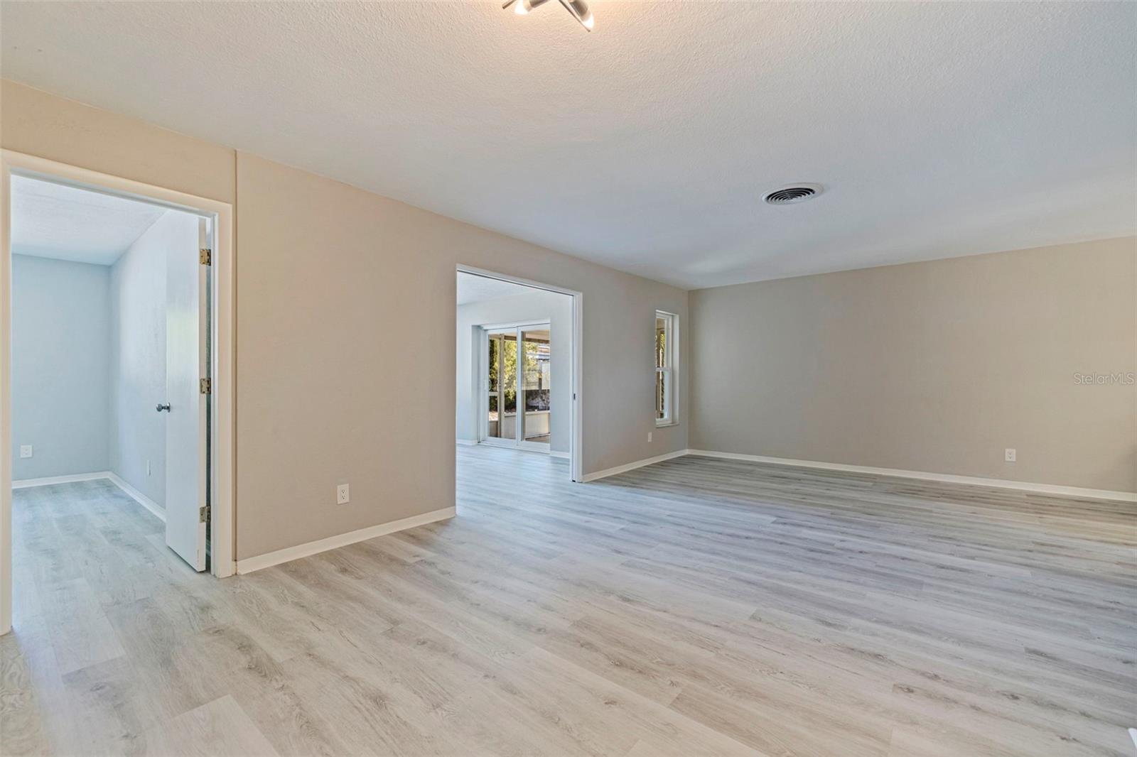 The living room with vinyl plank flooring and neutral tones throughout the home.