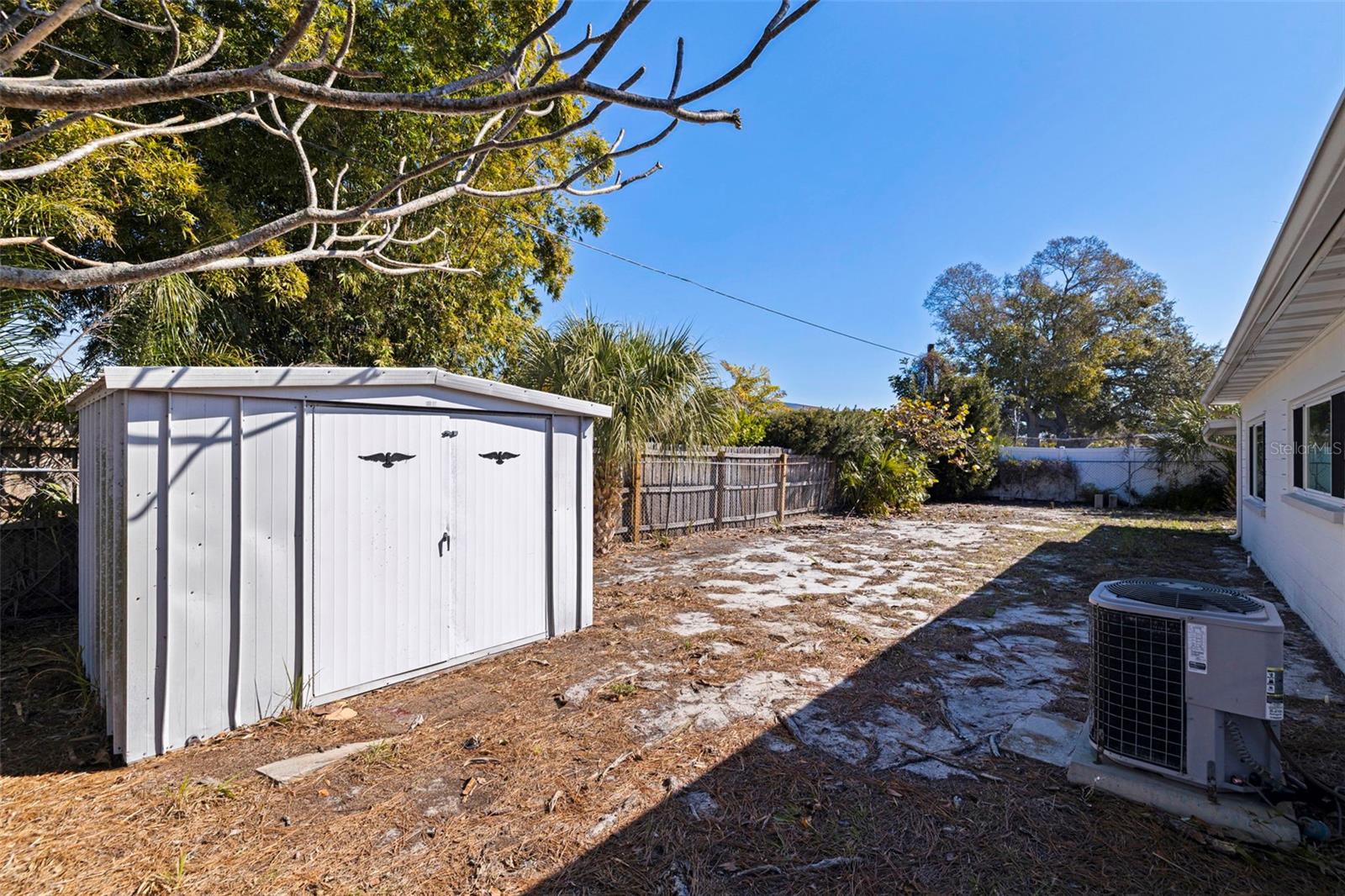 Detached storage shed for added utility and organization. The generous lot offers space for outdoor projects, gardening, or future enhancements, with mature trees providing natural shade and privacy. Exterior HVAC system conveniently located for easy access and maintenance.