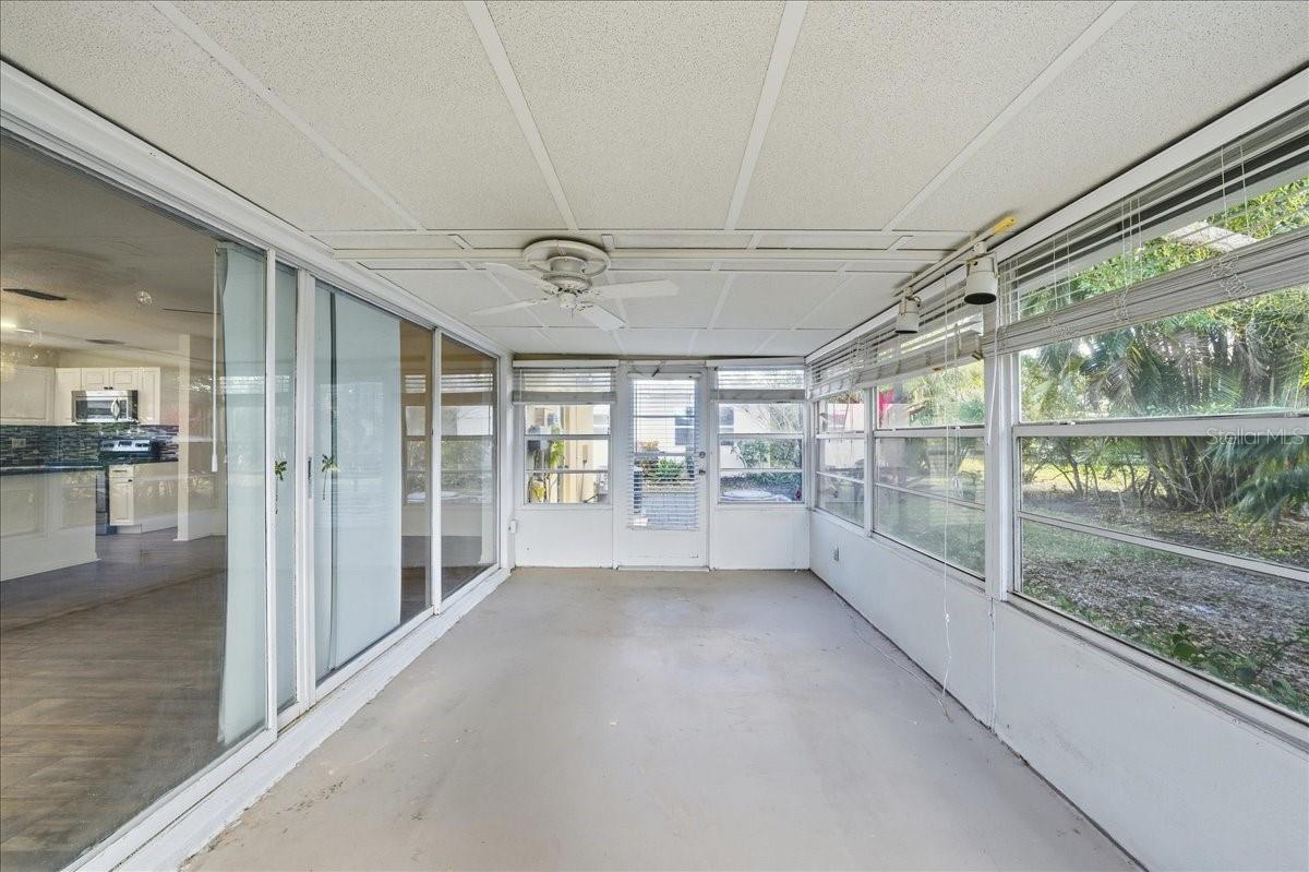 The spacious enclosed lanai offers a sunroom-style setting with surrounding windows, creating versatile bonus space ideal for reading, relaxing, or enjoying morning coffee.