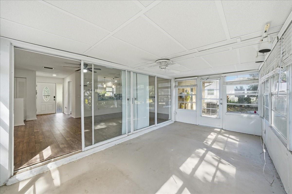 The spacious enclosed lanai offers a sunroom-style setting with surrounding windows, creating versatile bonus space ideal for reading, relaxing, or enjoying morning coffee.