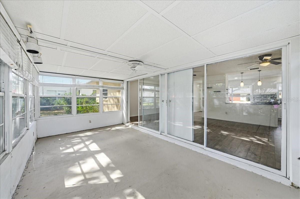 The spacious enclosed lanai offers a sunroom-style setting with surrounding windows, creating versatile bonus space ideal for reading, relaxing, or enjoying morning coffee.