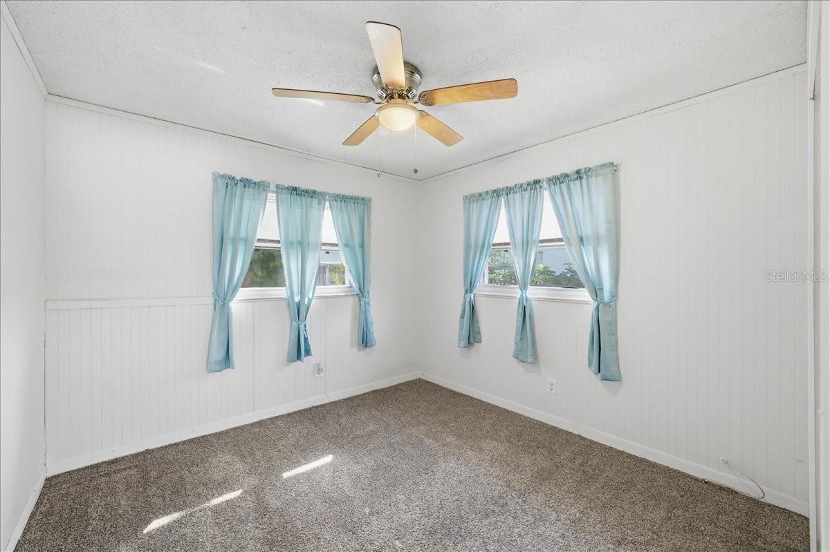 Second bedroom with wainscoting, two windows, wall closet and carpeting for comfort.