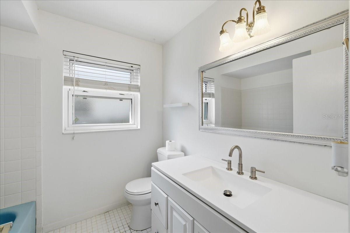 Second bathroom with updated vanity and a shower/tub combination.