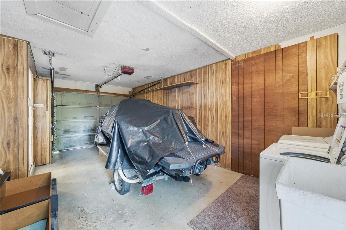 One car garage with utility area including sink, washer and dryer, and convenient kitchen entry.