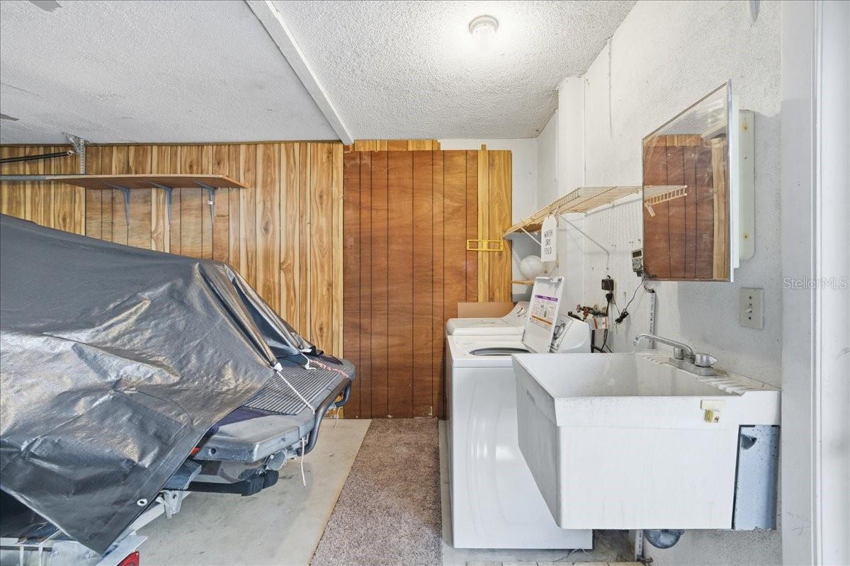 One car garage with utility area including sink, washer and dryer, and convenient kitchen entry.