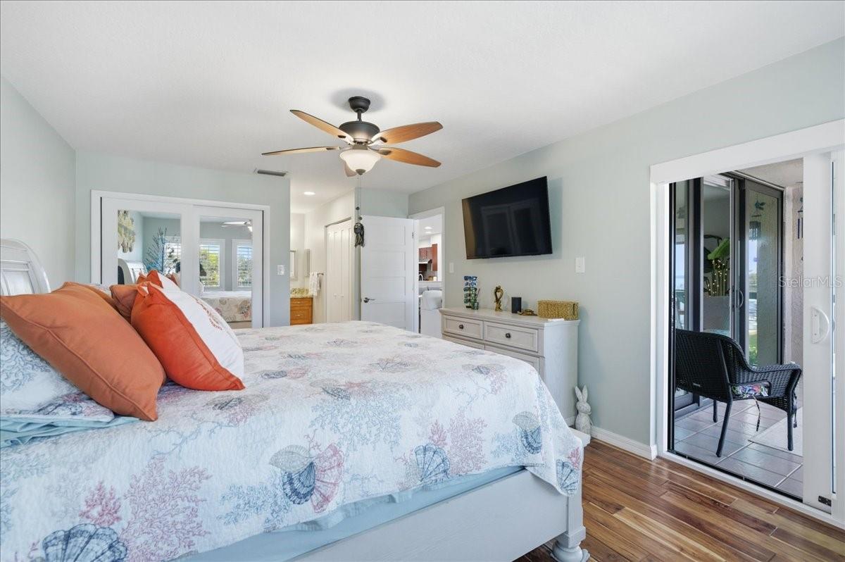 The primary bedroom enjoys beautiful water views, private sliding glass doors to the balcony, two closets with California Closet organizers, beautiful wood-look tile flooring, tastefully updated en-suite bathroom with a vanity room separate from the shower.