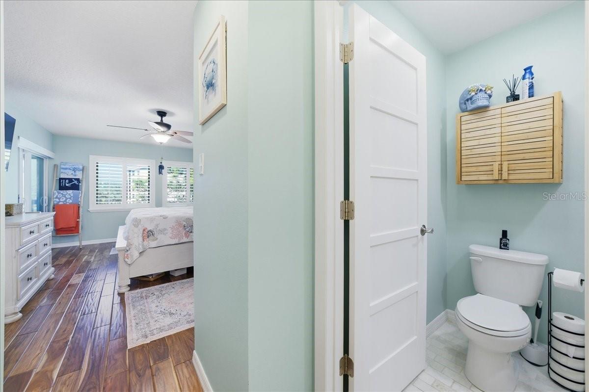 The primary bedroom enjoys beautiful water views, private sliding glass doors to the balcony, two closets with California Closet organizers, beautiful wood-look tile flooring, tastefully updated en-suite bathroom with a vanity room separate from the shower.