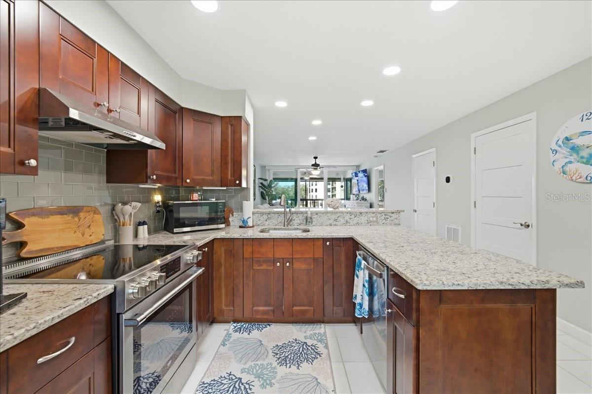 Stunning updated kitchen is well-equipped with stainless-steel appliances including a convection oven, rich cherry wood cabinets with soft closing cabinets and drawers, granite countertops, and beautiful, easy maintenance tile floors that flow into the main living areas.