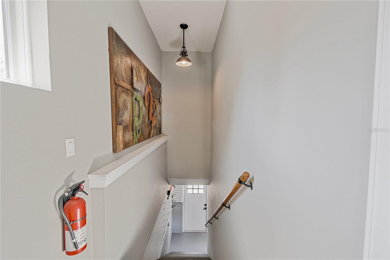 Stairs going down from office studio to garage and separate entrance outside