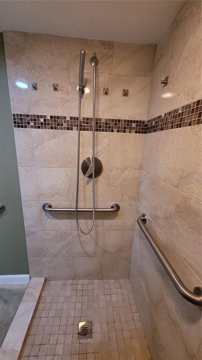 The primary bath suite has a custom designed walk in tiled shower with plenty of grab bars for safety.
