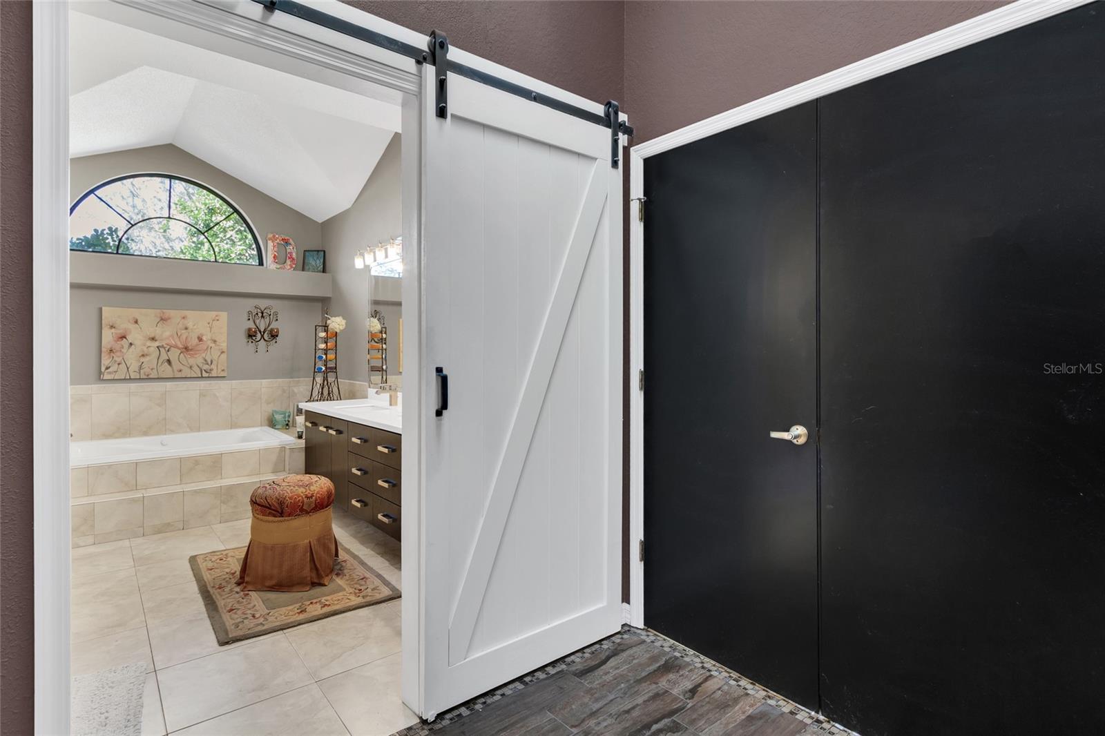 Barn door to en-suite, double door entry to primary bedroom
