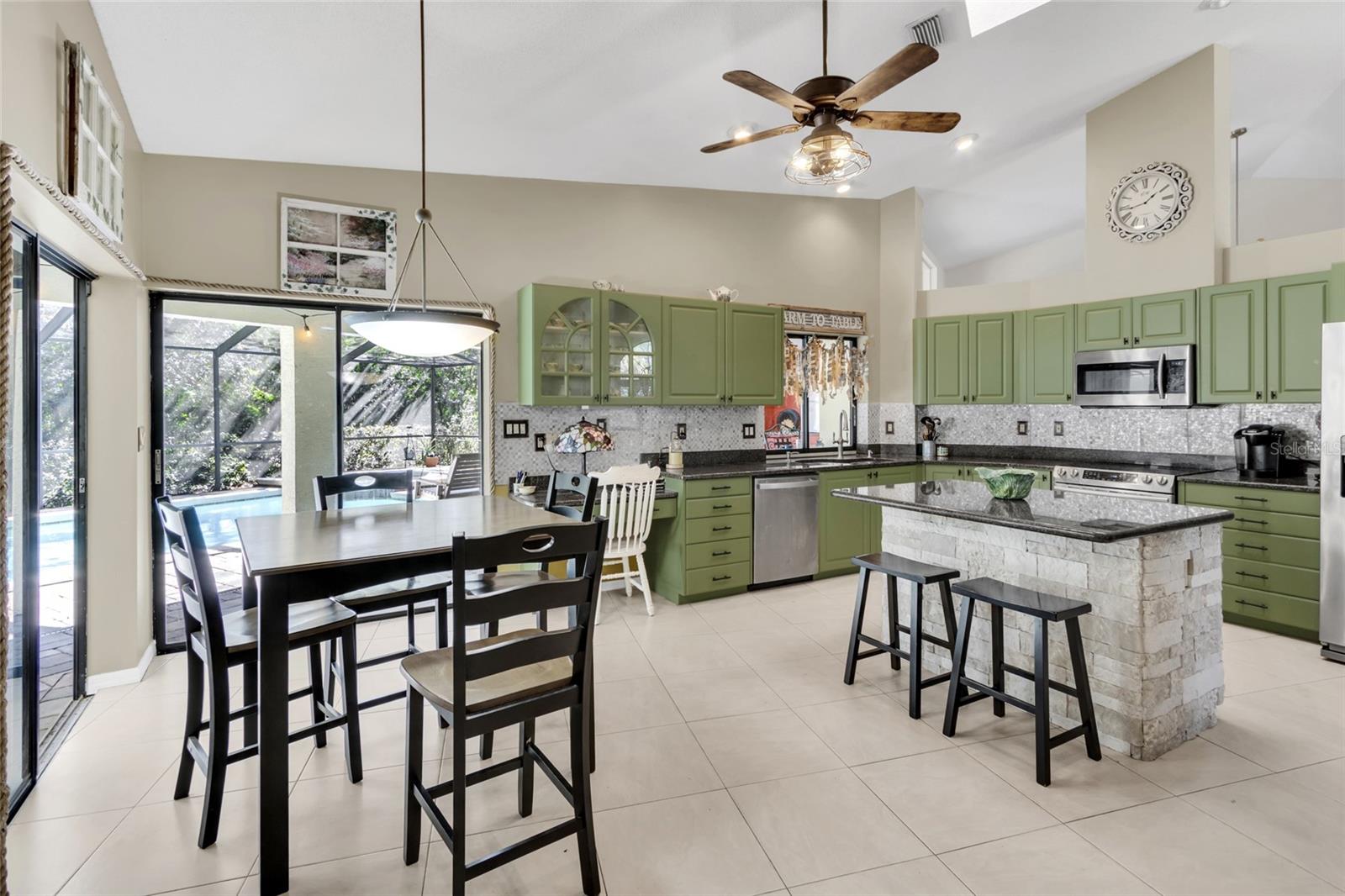 kitchen with eat in space and triple slider to pool deck