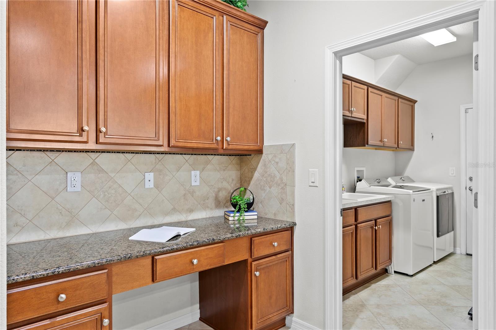 Laundry room is located next to built-in workstation